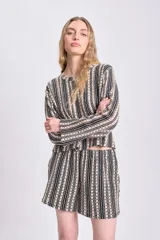 Top de punto crochet con diseño de rayas verticales en negro y beige, cuello redondo y textura calada con motivos florales.