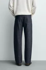Jeans de corte recto en denim azul oscuro, con mezcla de algodón y cáñamo sin lavados. Presenta diseño de cinco bolsillos, tiro medio y cierre frontal con cremallera y botón.