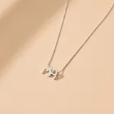 Collar de cadena fina de eslabones con un dije colgante que presenta las letras 'MA' en tipografía redondeada, fabricado en plata 925.