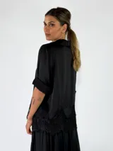 Camisa de manga larga color violeta, con cierre frontal de botones y detalle de encaje aplicado en el ruedo.