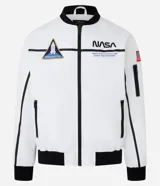 Campera tipo bomber blanca con detalles en negro, inspirada en uniformes espaciales de la NASA. Presenta parches con el logo de la NASA, la bandera de EE. UU. y texto en la manga que dice "Kennedy Space Center".