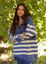 Buzo de lana merino con diseño a rayas horizontales en azul y blanco, cuello alto con cierre frontal y mangas largas.