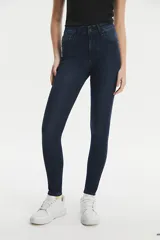 Jean de corte skinny y tiro alto, en color azul oscuro con acabado uniforme. Presenta cierre frontal con botón y cremallera, y diseño clásico de cinco bolsillos.