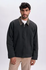 Campera gris oscuro de lona, con cuello camisero de pana en tono contrastante y cierre frontal con cremallera metálica.