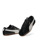 Championes Puma modelo Tackle OG, de diseño clásico con capellada en cuero negro y puntera de gamuza al tono. Presenta la icónica franja lateral de la marca en color blanco y detalles de logo en dorado. Cuenta con suela de goma color caramelo.