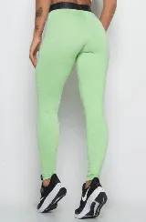 Calza deportiva color verde claro, de tiro alto y corte ajustado. Presenta cintura elástica con logo en relieve.