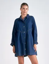 Vestido camisero de denim azul oscuro, marca Elan. Tiene cuello con solapa, abertura central con botones metálicos dorados, bolsillos laterales, mangas largas con puño elastizado, largo mini y calce holgado.