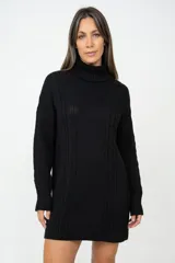 Polerón largo de punto color negro, con cuello alto tipo tortuga y diseño de trenzado vertical. Presenta mangas largas con puños acanalados y un corte holgado que permite usarlo como vestido.