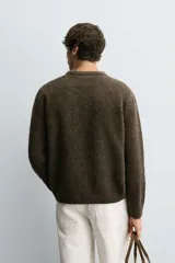 Jersey de punto con lana, corte relajado, cuello redondo y manga larga. Presenta un diseño de rombos en tonos marrón, beige y rojo con detalles bordados, y acabados en rib.