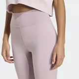 Calza deportiva Adidas de tiro alto, confeccionada en tejido suave y flexible con tecnología AEROREADY que absorbe la humedad. Presenta un ajuste ceñido y costuras contorneadas para mayor comodidad durante el entrenamiento.