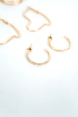 Set de tres pares de aros plateados de diseño variado: un par de argollas dobles, un par de aros con forma de corazón y un par de argollas pequeñas con textura rayada.