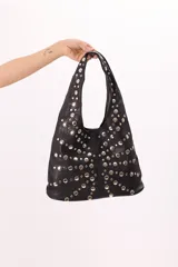 Bolso hobo de símil cuero negro con apliques metálicos plateados.