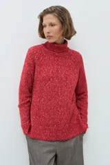 Polerón de cuello alto confeccionado en tejido buclé con textura jaspeada, de corte holgado y mangas largas con diseño raglán.