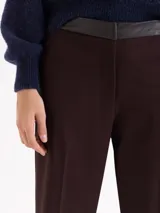 Pantalón de corte recto confeccionado en tela sastrera, con cintura de cuero vacuno, raya marcada en el centro de las piernas y bolsillos laterales.