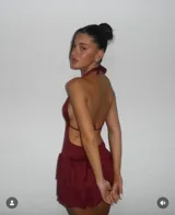 Vestido corto color bordó con escote halter, espalda descubierta y falda con volados.