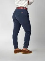 Pantalón de pana negro de corte recto, con bolsillos laterales y traseros. Se ajusta a la cintura con cinturón de cuero negro.