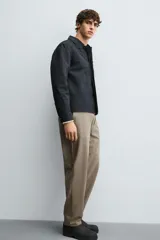 Pantalón regular fit color azul marino, confeccionado en tejido elástico. Cuenta con bolsillos frontales, bolsillos traseros de vivo con botón y cierre frontal con cremallera y botón.