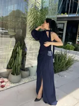 Vestido largo azul marino de fiesta con un solo hombro, abertura lateral y detalle de lazo en la cintura.