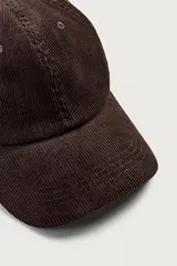 Gorra de seis paneles confeccionada en pana de algodón con visera curva y ajuste en la parte posterior.
