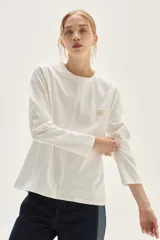 Remera de algodón de corte recto, con cuello a la base y mangas largas. Presenta costuras con pespuntes a contratono y un pequeño bordado en el pecho.