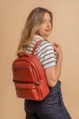 Mochila de cuero sintético color negro con textura granulada. Cuenta con un compartimento principal con cierre, un bolsillo frontal con cierre, correas ajustables y asa superior.