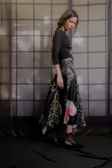 Falda midi de tiro medio confeccionada en tela sedosa color azul marino, con aberturas frontales y traseras que aportan movimiento, y estampado floral en la parte inferior.
