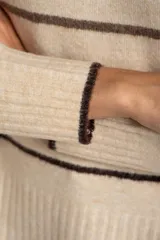 Sweater de punto con diseño de rayas horizontales en tonos neutros, cuello redondo, manga larga y puños acanalados.