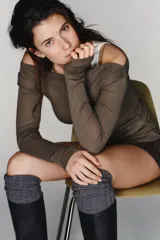 Camiseta de manga larga con diseño asimétrico y efecto de doble capa. Presenta un cuello redondo y un detalle de fruncido lateral que aporta textura a la prenda.