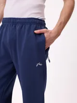 Babucha gris de algodón y poliéster, con cintura elástica, cordón ajustable y bolsillos laterales. Presenta el logo de Rusty bordado en el muslo izquierdo.