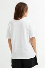 Remera blanca de algodón con cuello redondo y mangas cortas, corte recto y tajo lateral.