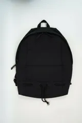 Bolso tipo tote bag color beige con asas superiores de hombro, cordones ajustables a los lados con detalles metálicos y un pequeño anillo frontal.