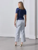 Pantalón wide leg con estampado de rayas verticales celestes y blancas, pretina con botón, bolsillos simulados en la parte delantera y ruedo con dobladillo.