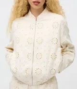 Campera bomber de sarga color beige con textura de laise floral, cuello alto, cierre frontal con cremallera y ruedo elástico.