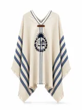 Poncho de hilo de algodón grueso color beige, con escote en V, detalles de rayas azules en los laterales y el escudo nacional uruguayo bordado en la parte frontal. Cuenta con terminaciones de flecos en los bordes.