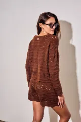 Sweater oversize de tejido de punto color blanco con diseño calado de ondas y cuello redondo, de manga larga.