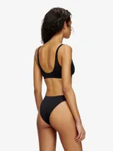 Sujetador tipo bralette de encaje con estampado camuflado en tonos marrones/beige. Tiene tirantes finos y un pequeño logo en el centro del busto.