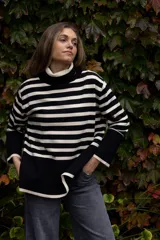 Poleron de punto con diseño a rayas horizontales en color beige y negro, cuello alto tipo tortuga, mangas largas con puños anchos y aberturas laterales en el ruedo.