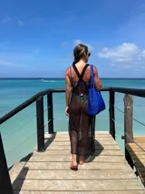 Vestido playero negro de red con aberturas laterales.