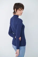 Polera de tejido morley color azul, con cuello alto y mangas largas, de corte ajustado al cuerpo.