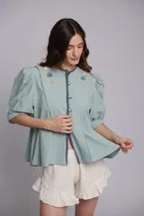 Short blanco de algodón con cintura elástica y detalle de volados con pompones en el ruedo.