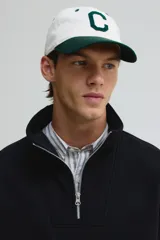 Buzo negro de tejido pesado con interior cepillado suave, cuello alto y cierre frontal parcial plateado. Presenta hombros caídos y puños y bajo en punto acanalado.