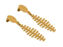 Aros colgantes de acero dorado con forma de esqueleto de pez.