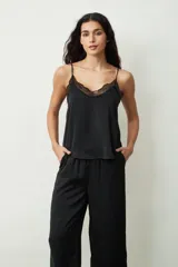 Blusa de tirantes finos en color negro, confeccionada en satén con sutiles brillos, destacando por un delicado detalle de encaje en el escote en V.