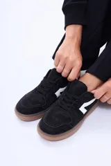 Championes urbanos de diseño minimalista, color blanco con detalles en verde oliva en los laterales y suela de goma color caramelo.