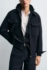 Sobrecamisa de corte regular fit confeccionada en tejido con mezcla de lana. Presenta cuello solapa, cierre frontal con cremallera, bolsillos de plastrón con solapa en el pecho y bolsillos laterales. Las mangas largas terminan en puños con botón oculto.