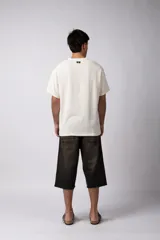 Remera de manga corta con cuello redondo, confeccionada en tejido de lino con textura entramada y corte holgado.