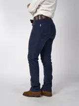 Pantalón de pana azul marino, de corte recto y calce ajustado, con cinco bolsillos y cinturón de cuero marrón.