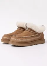 Pantuflas UGG color marrón con interior de piel sintética color beige.