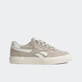 Championes Reebok Court Advance Vulc color beige con detalles blancos y suela tostada. Presentan una parte superior de lona, rayas vectoriales blancas en los laterales y una construcción vulcanizada con microburbujas DMX para mayor comodidad.