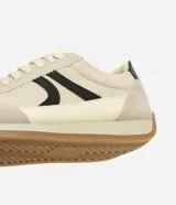 Championes estilo runner de diseño vintage, confeccionados en una combinación de tejido de malla respirable, recortes de gamuza y detalles en material sintético. Presentan cierre con cordones, detalle lateral aplicado en contraste y suela de goma plana con base color caramelo.